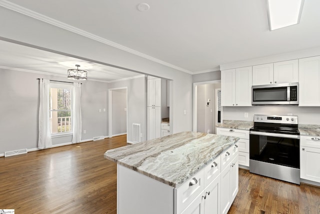 kitchen featuring white cabinetry, a kitchen island, light stone countertops, and appliances with stainless steel finishes