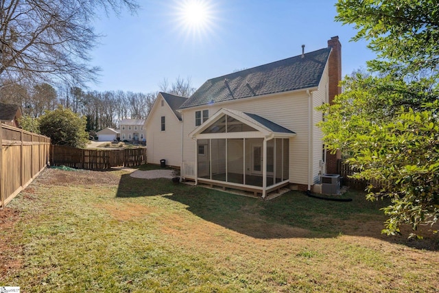 back of property featuring a sunroom, a yard, and cooling unit