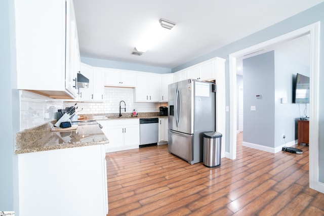 kitchen featuring light stone counters, sink, stainless steel appliances, and white cabinets