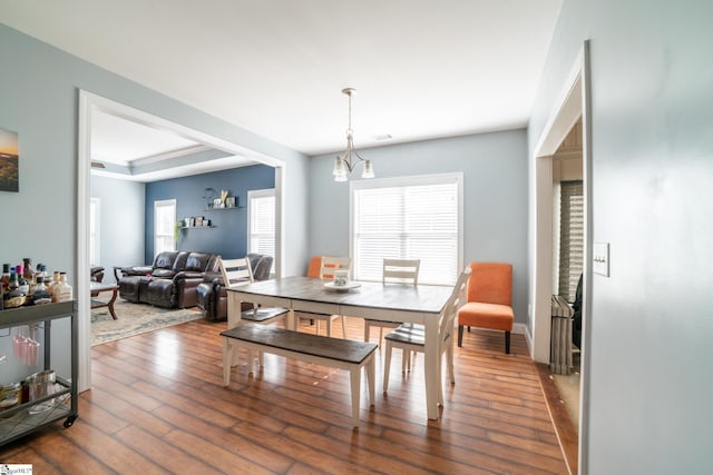 dining area featuring hardwood / wood-style floors and a raised ceiling