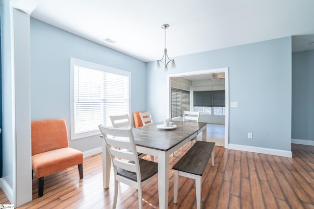 dining space featuring hardwood / wood-style floors and a notable chandelier