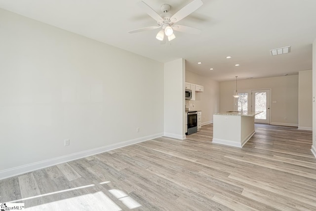 unfurnished living room featuring sink, light hardwood / wood-style flooring, and ceiling fan