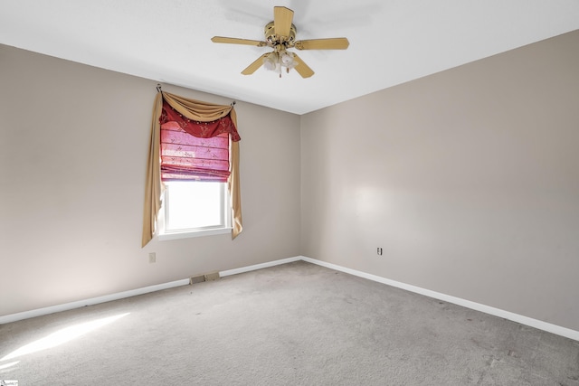 carpeted spare room with ceiling fan