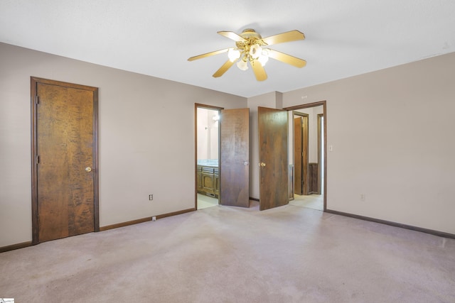 unfurnished bedroom featuring ceiling fan, ensuite bathroom, and light carpet