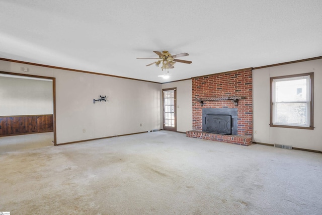 unfurnished living room featuring ornamental molding, light carpet, and ceiling fan