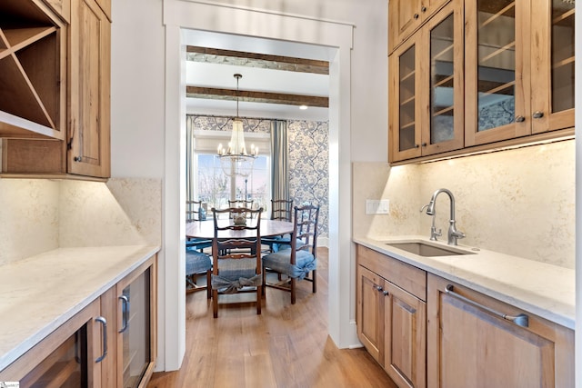 kitchen with pendant lighting, beam ceiling, sink, and backsplash