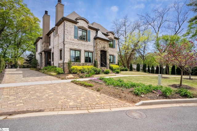 french country inspired facade with a front lawn