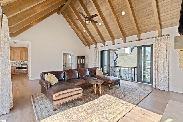 living room featuring high vaulted ceiling, beamed ceiling, ceiling fan, wooden ceiling, and light wood-type flooring