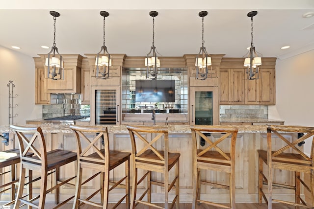 kitchen with light stone counters, light brown cabinetry, and backsplash