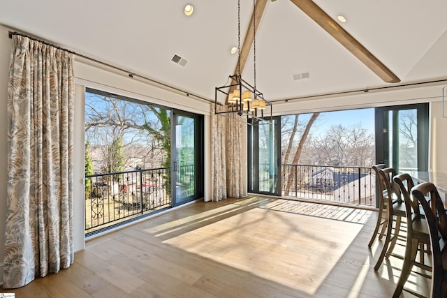 unfurnished dining area featuring beamed ceiling, wood-type flooring, an inviting chandelier, and high vaulted ceiling