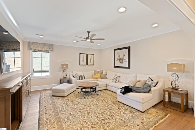 living room with hardwood / wood-style floors, crown molding, and ceiling fan