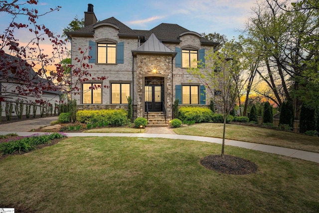 french provincial home with a lawn