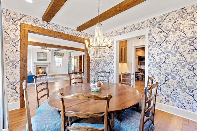 dining space featuring beam ceiling and light hardwood / wood-style flooring