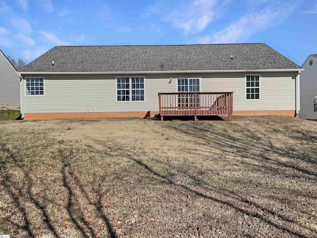 back of house with a deck and a lawn