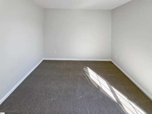 empty room featuring dark colored carpet