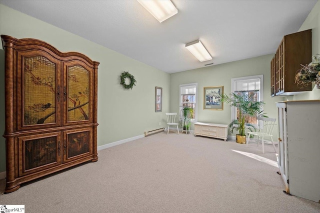 sitting room featuring a baseboard heating unit and light colored carpet