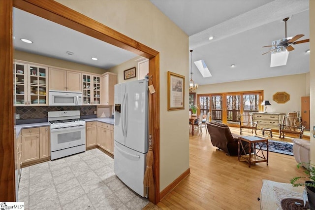 kitchen featuring vaulted ceiling with skylight, light brown cabinetry, tasteful backsplash, ceiling fan, and white appliances