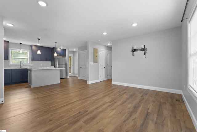 unfurnished living room with dark wood-type flooring and sink