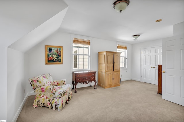 sitting room featuring lofted ceiling and light carpet