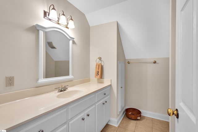 bathroom with vanity, lofted ceiling, and tile patterned floors