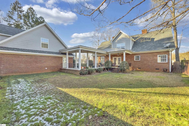 rear view of property with a lawn