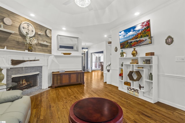 living room with ornamental molding, hardwood / wood-style floors, and a tray ceiling