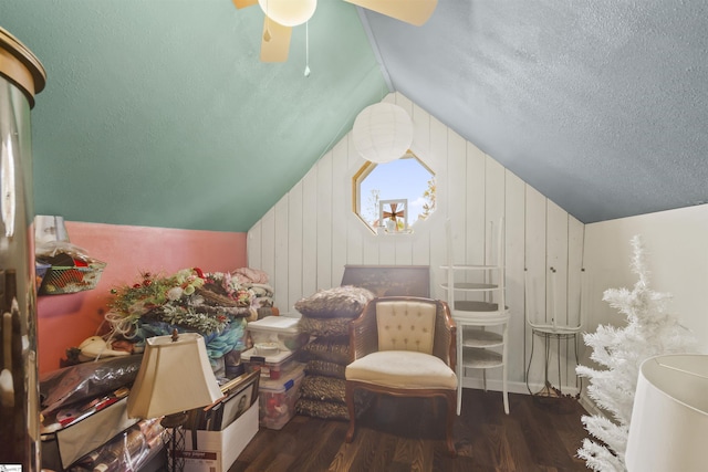 bedroom featuring dark wood-type flooring, vaulted ceiling, wooden walls, and ceiling fan