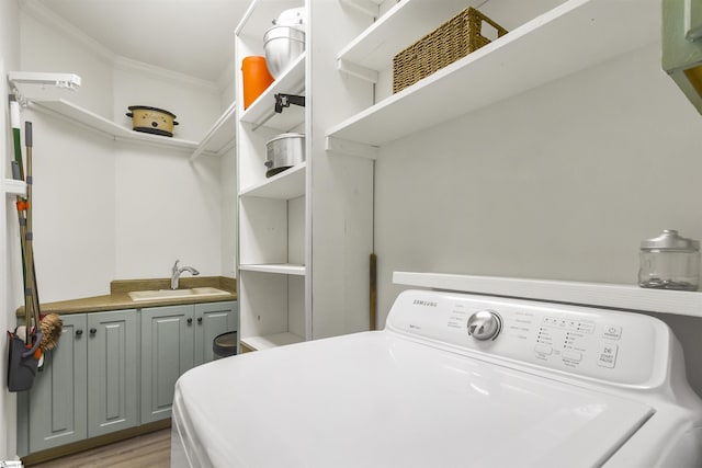 washroom with washer / dryer, sink, cabinets, ornamental molding, and light hardwood / wood-style floors