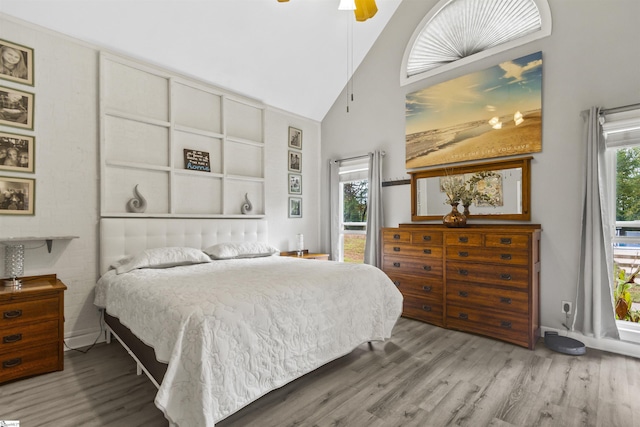 bedroom featuring hardwood / wood-style flooring, high vaulted ceiling, and ceiling fan