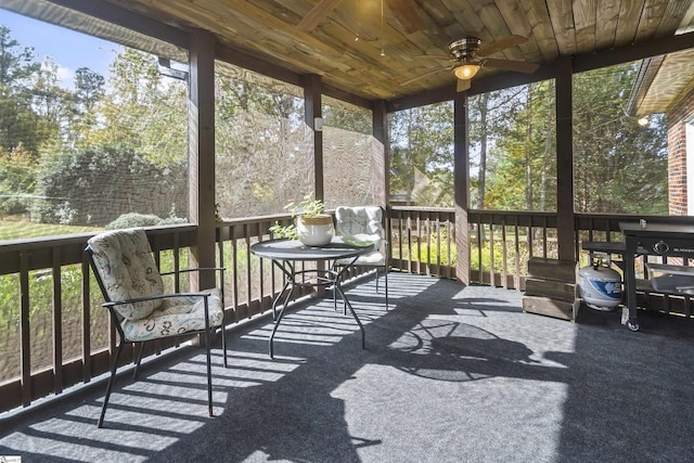 sunroom / solarium featuring a healthy amount of sunlight, wooden ceiling, and ceiling fan