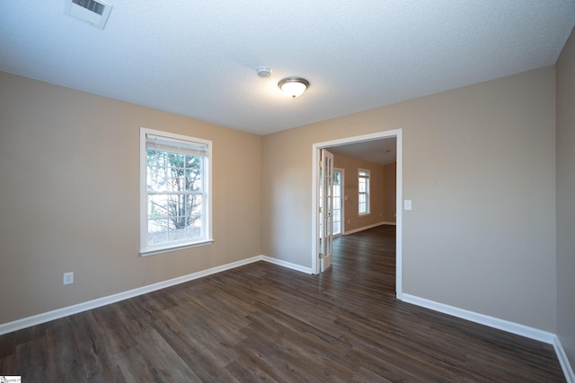 unfurnished room with dark wood-type flooring and a textured ceiling