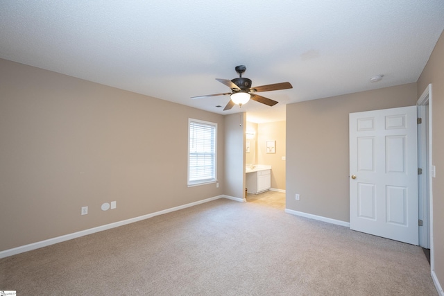 unfurnished bedroom with light carpet, ensuite bath, and ceiling fan