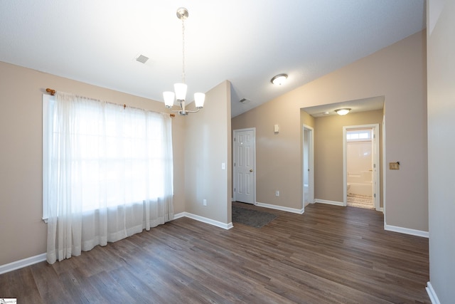 unfurnished room featuring vaulted ceiling, dark wood-type flooring, and a notable chandelier