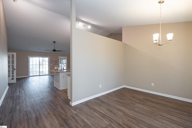 empty room with dark hardwood / wood-style flooring, sink, ceiling fan with notable chandelier, and vaulted ceiling