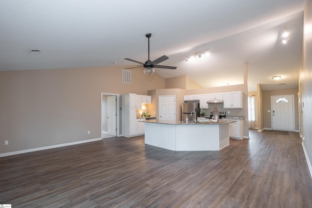 kitchen featuring stainless steel refrigerator, ceiling fan, white cabinetry, dark hardwood / wood-style floors, and a center island with sink