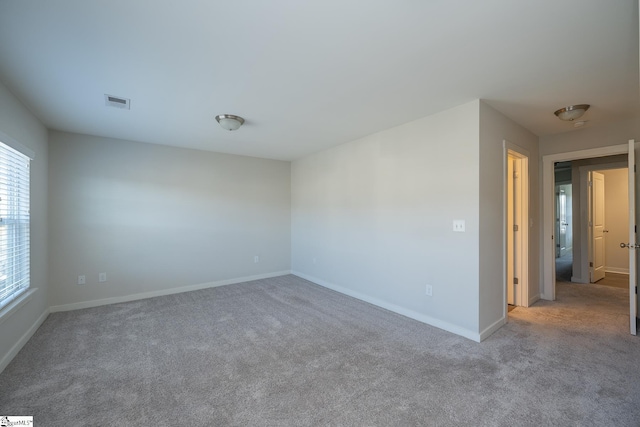 spare room featuring light colored carpet