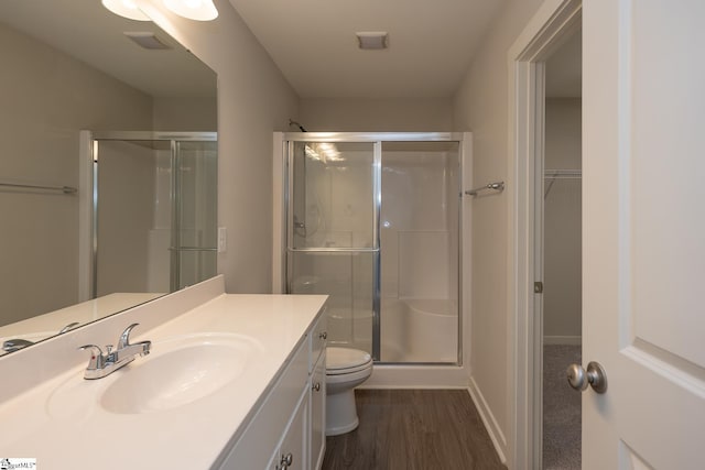 bathroom with a shower with door, vanity, hardwood / wood-style flooring, and toilet