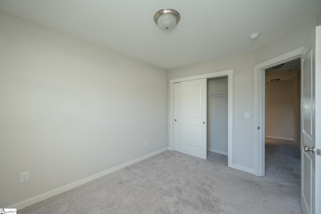 unfurnished bedroom featuring light colored carpet and a closet