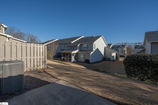 view of side of property featuring a yard, central AC, and a patio