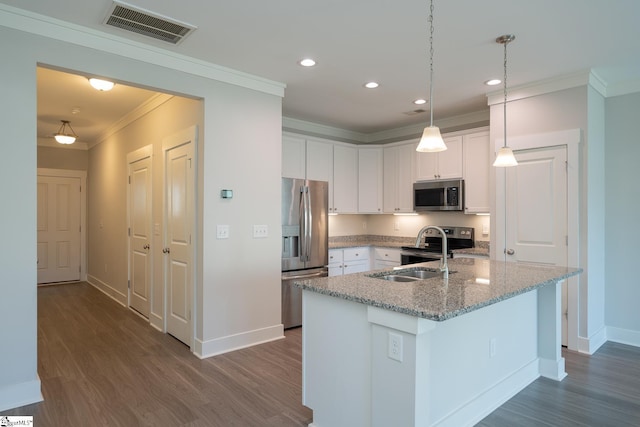 kitchen featuring sink, decorative light fixtures, appliances with stainless steel finishes, a kitchen island with sink, and white cabinets