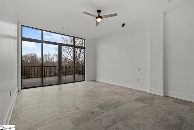 unfurnished room featuring ceiling fan and floor to ceiling windows