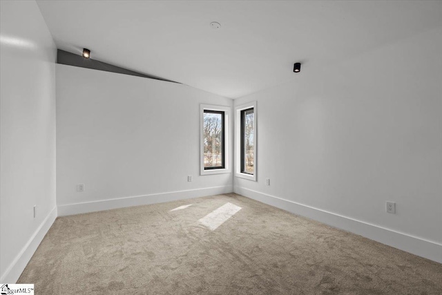 carpeted empty room with lofted ceiling