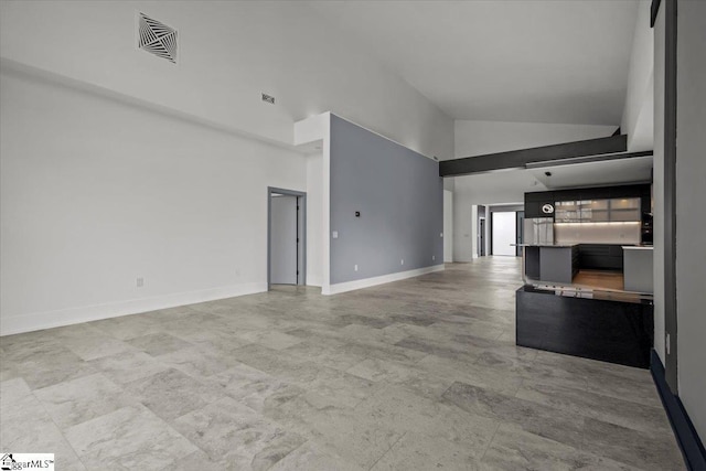 unfurnished living room with high vaulted ceiling