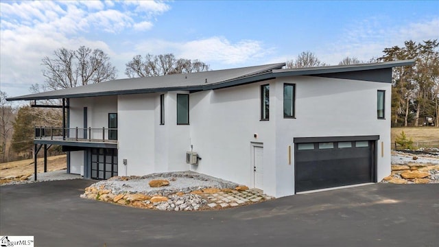 view of side of property featuring a garage and a balcony