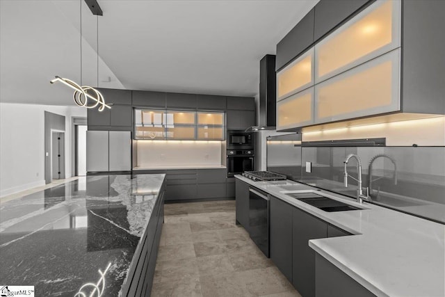 kitchen featuring ventilation hood, sink, dark stone countertops, hanging light fixtures, and black appliances