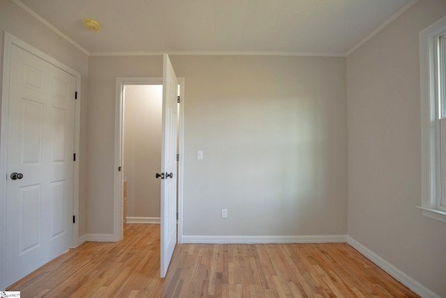 spare room featuring crown molding and light hardwood / wood-style flooring