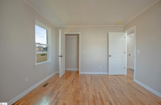 unfurnished bedroom featuring crown molding and light wood-type flooring