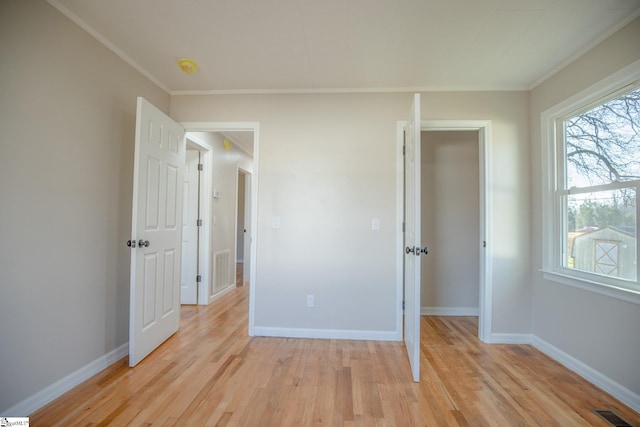 unfurnished bedroom featuring crown molding, light hardwood / wood-style flooring, and a closet