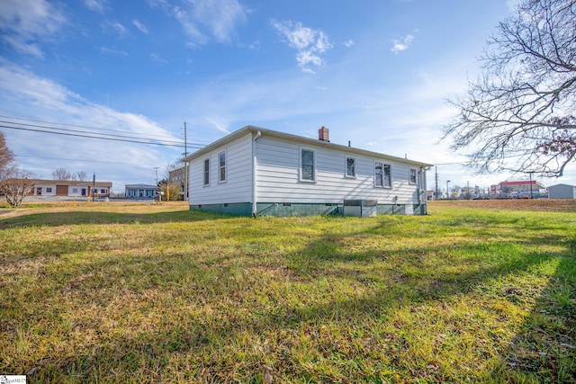 view of side of property with a yard and cooling unit