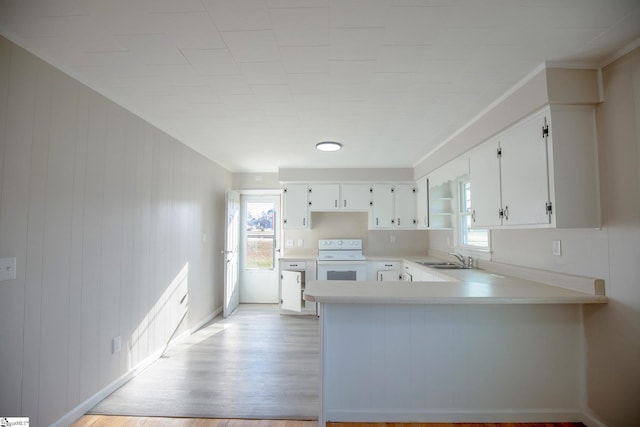 kitchen featuring sink, light hardwood / wood-style flooring, range, white cabinetry, and kitchen peninsula